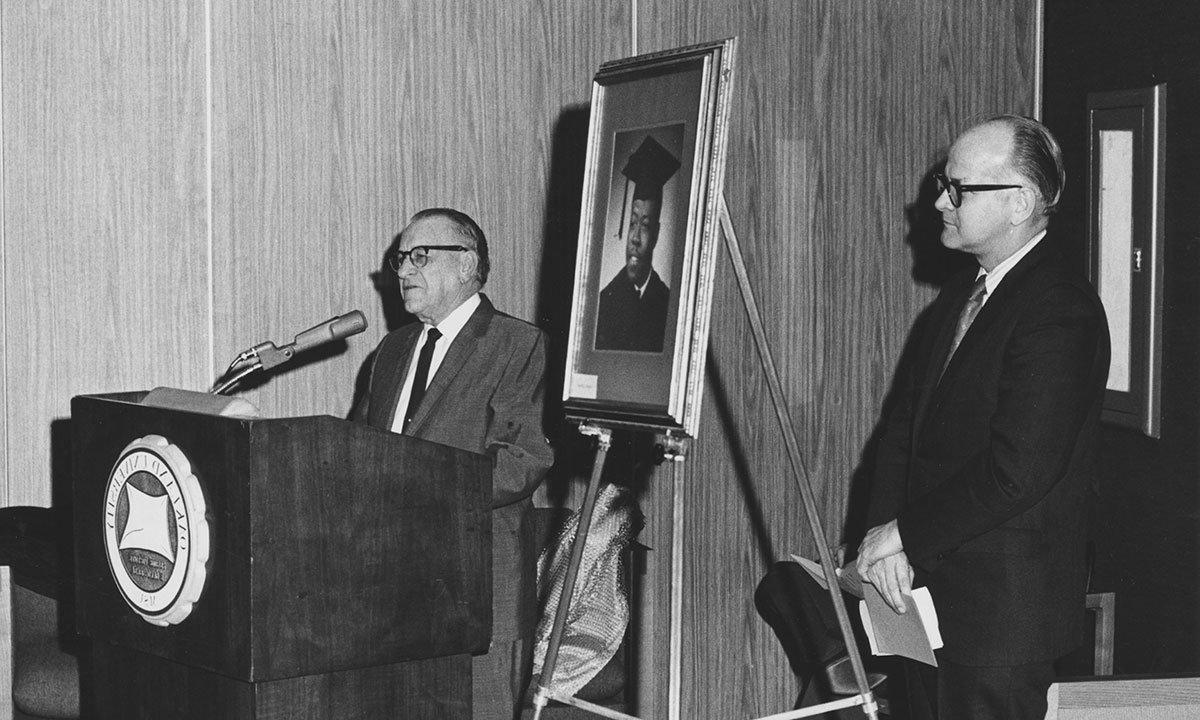 A man at a podium, talking.